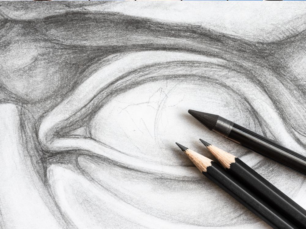 An image of an eye sketch with three pencils.