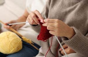 An image of a woman learning how to knit.