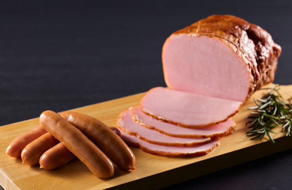 An image of a honey glazed ham with sausages.