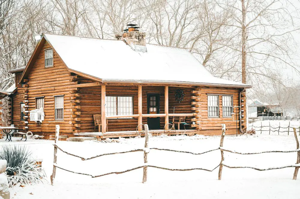 An image of a log cabin in the snow.