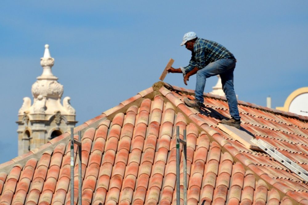 A roofing contractor repairing a roof.