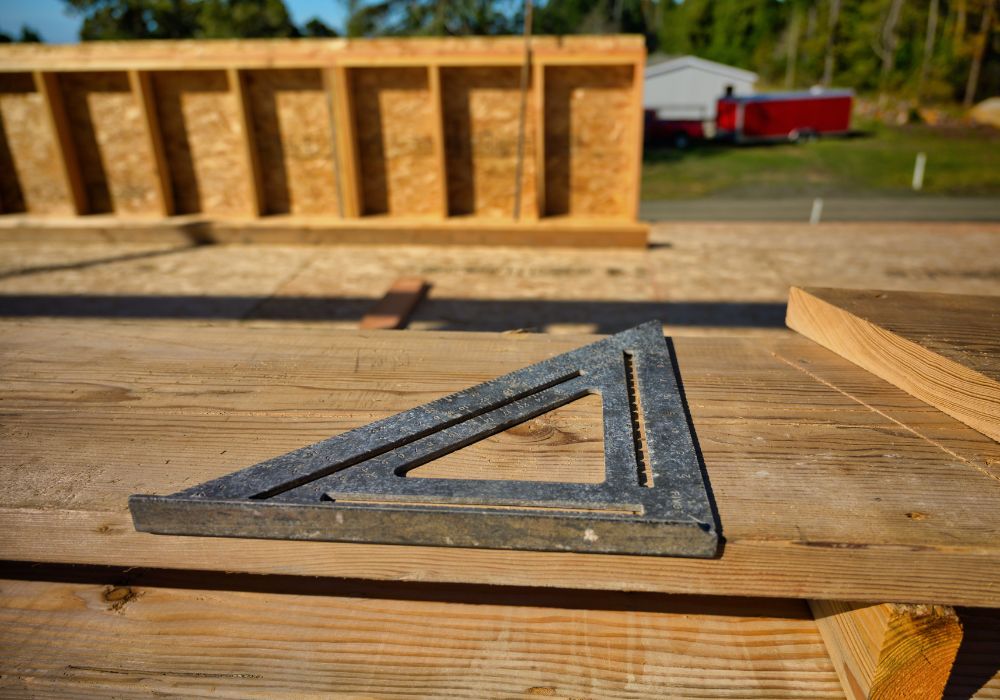 An image of a used speed square on top of a wood material. 