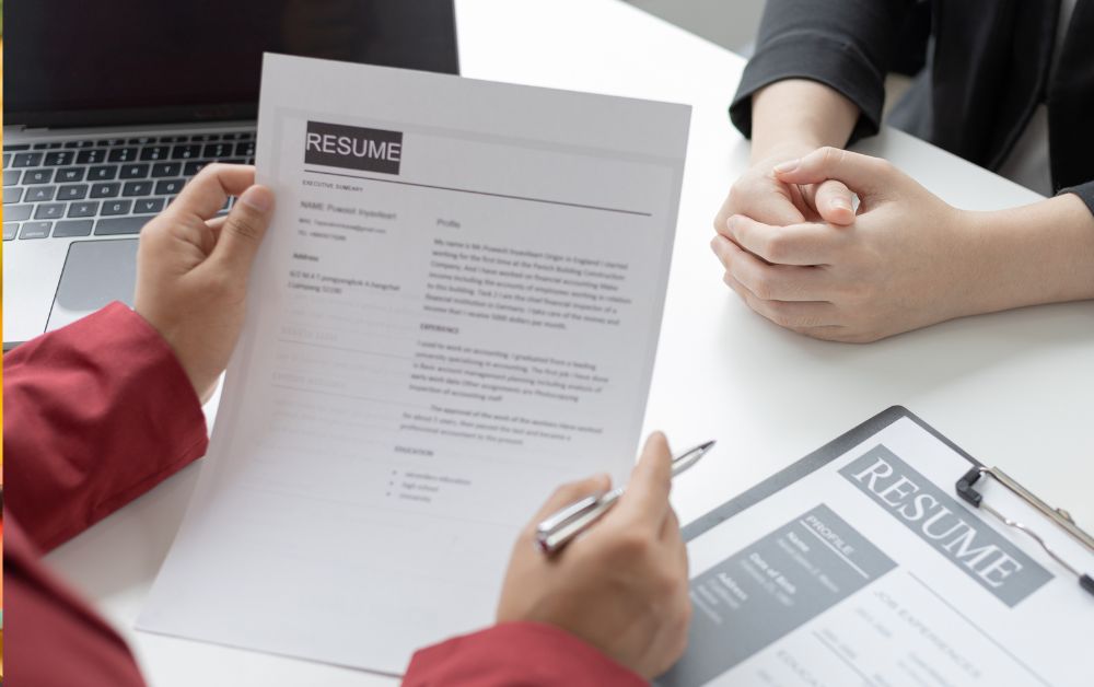 An image of a recruiter reading a resume for an article about AI job recruiting.