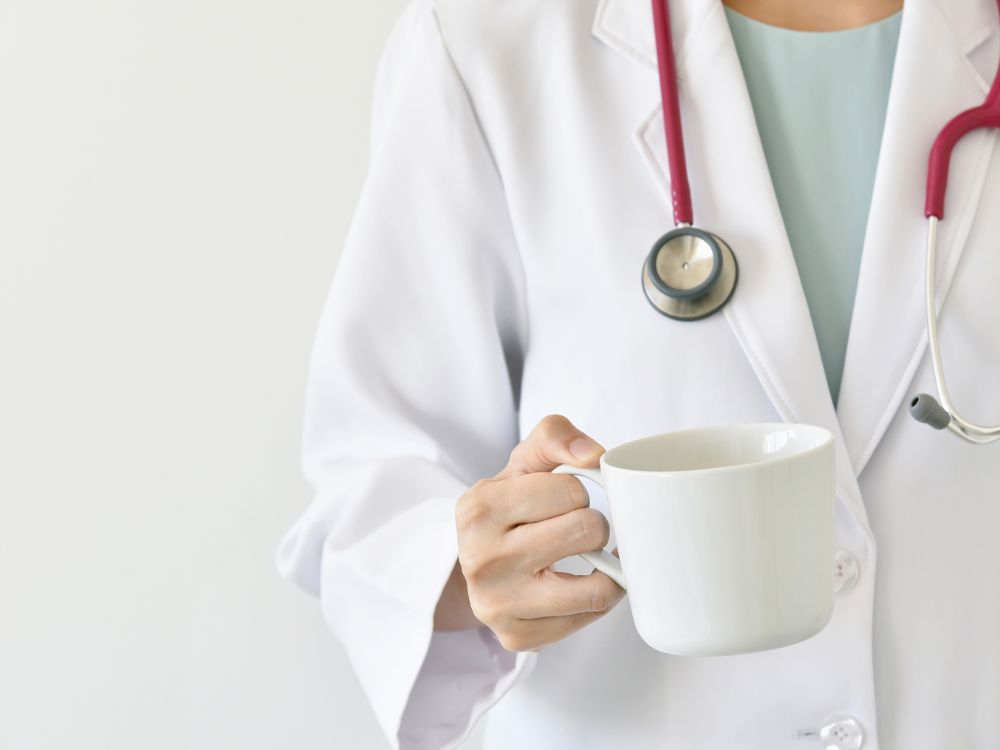 an image of a doctor holding a cup of coffee. 